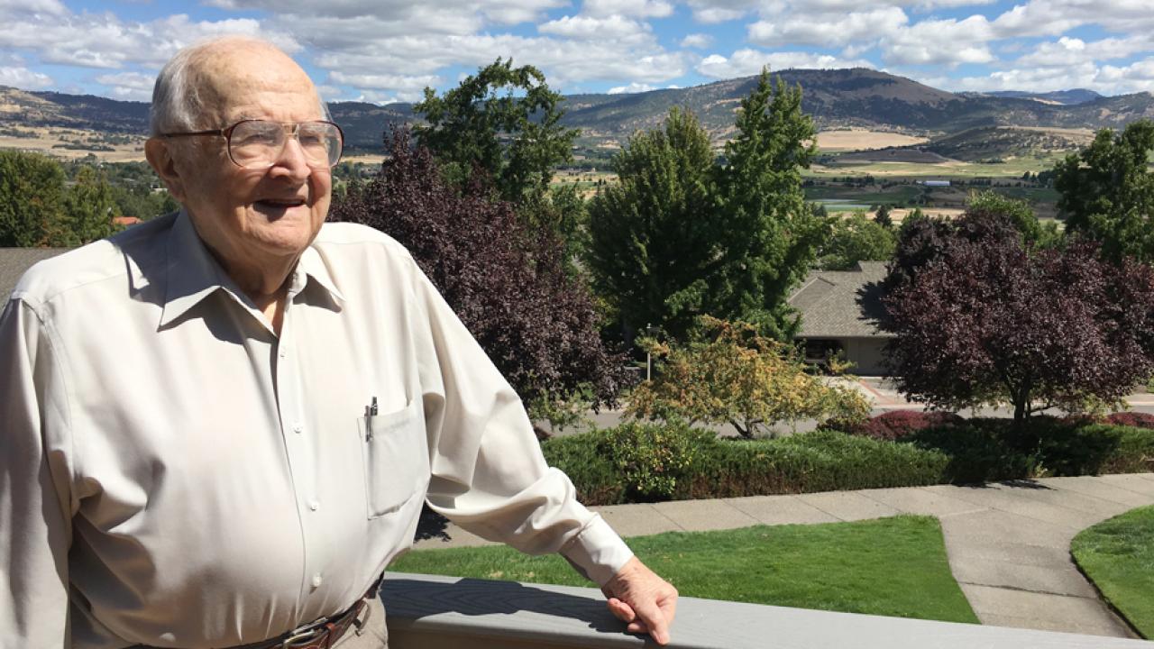 John D. Kemper on balcony, scenery behind