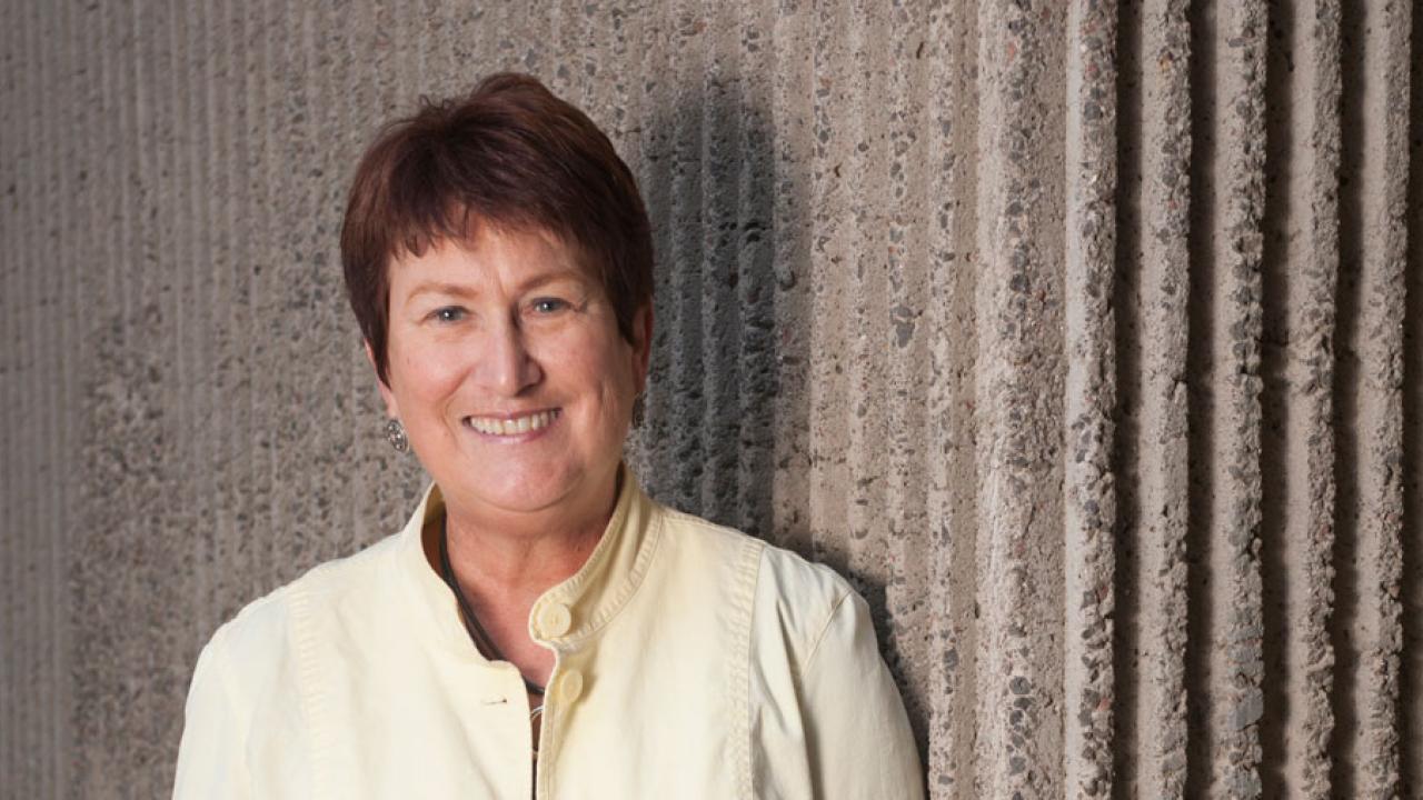 Judith A. Kjelstrom, environmental, standing against concrete wall