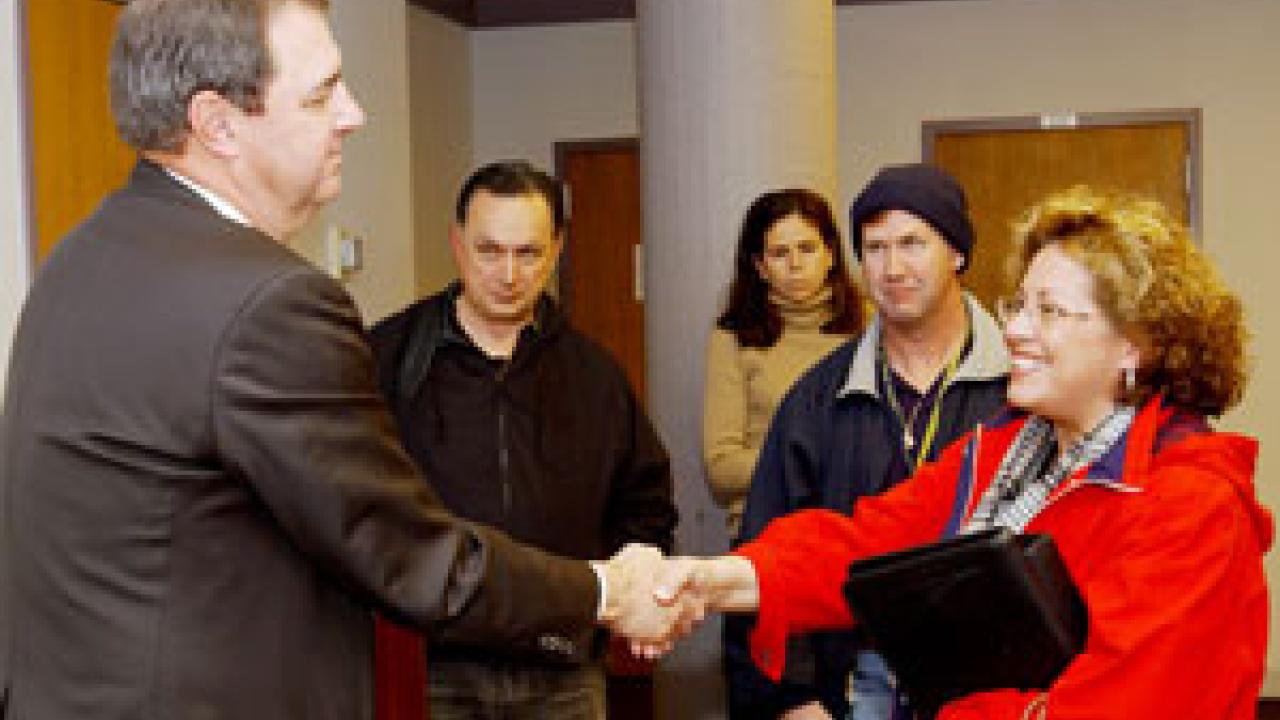 Jerry Kissler of the UC Office of the President greets Linda Mijangos, a program manager for the College of Agricultural and Environmental Sciences, after addressing the Staff Assembly.