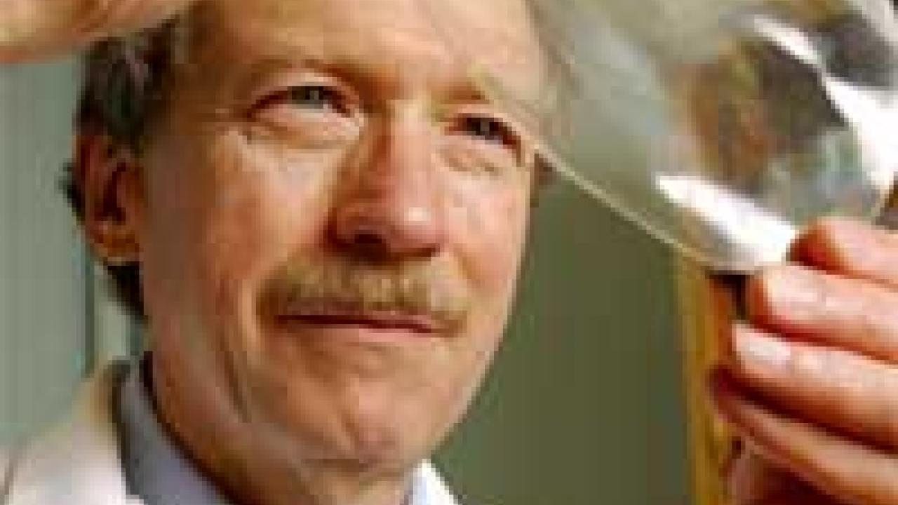 Photo: man in white coat looking at big bubble