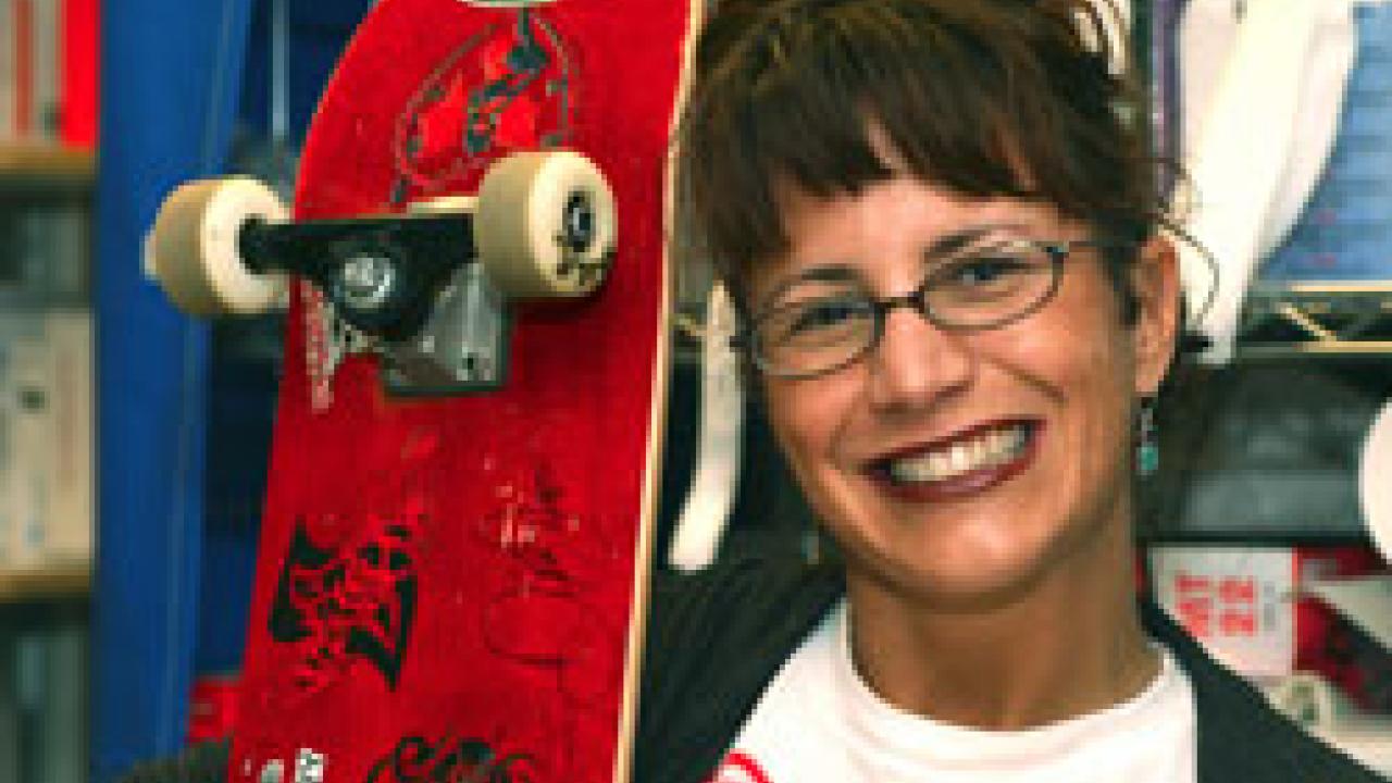 Lisa Girsh shows off the skateboard autographed by NASCAR driver Dale Earnhardt Jr., after he was hospitalized briefly last month at the medical center.  