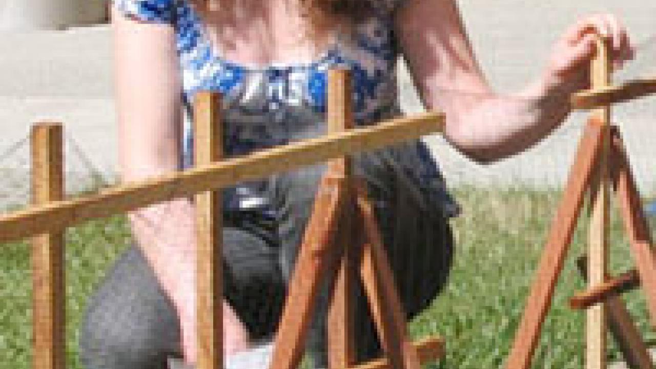 Photo: Margaret Lloyd kneeling next to a garden.