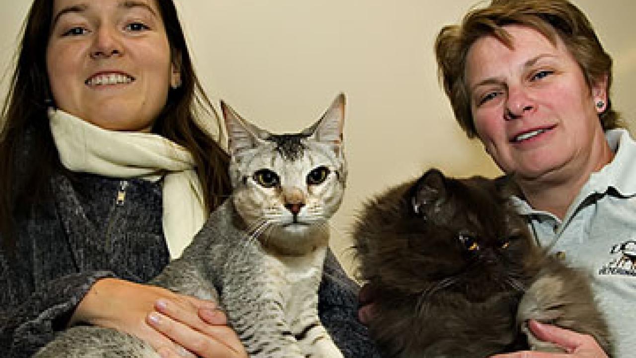 Photo: Two women holding cats.