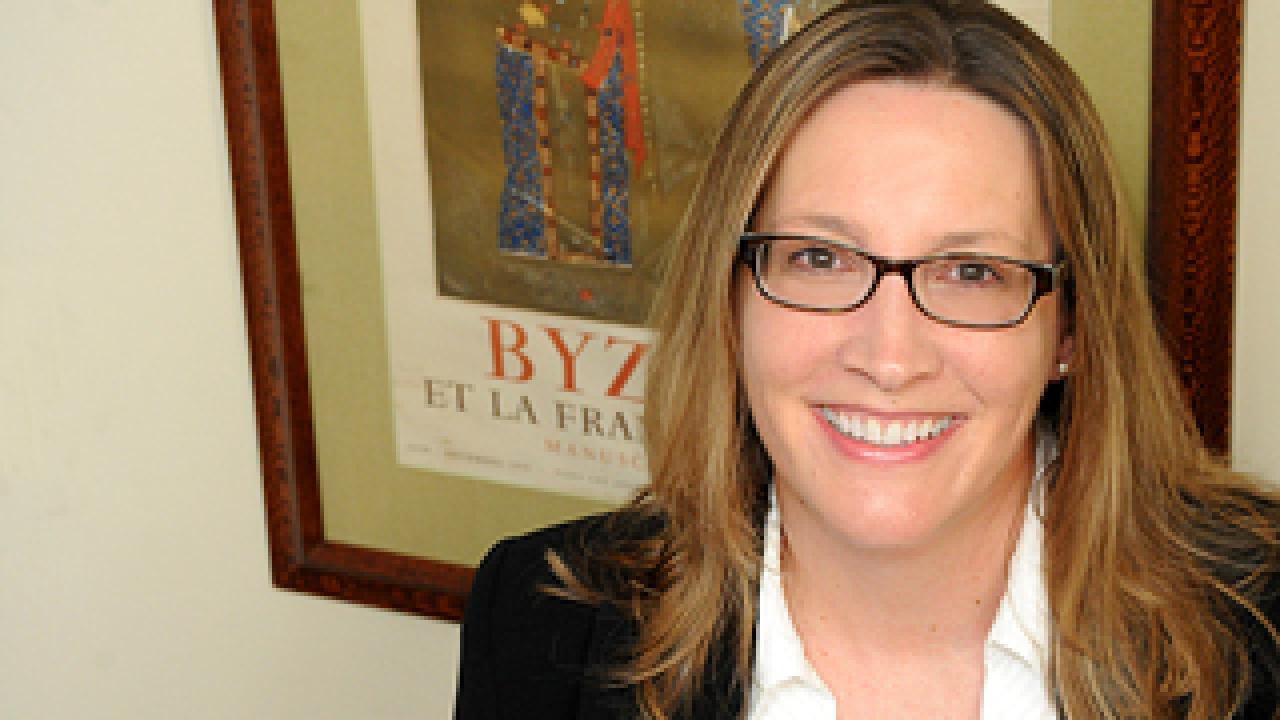 Photo: MacKenzie Smith posing in front of a framed poster.