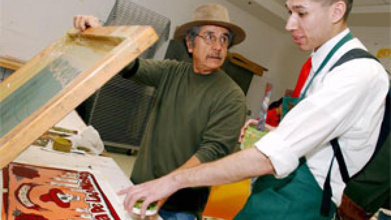 Malaquias Montoya of Chicana/o Studies, works with Pete Benites, a fourth year student, on his print as part of a program that will eventually help teach art to Woodland youth.           