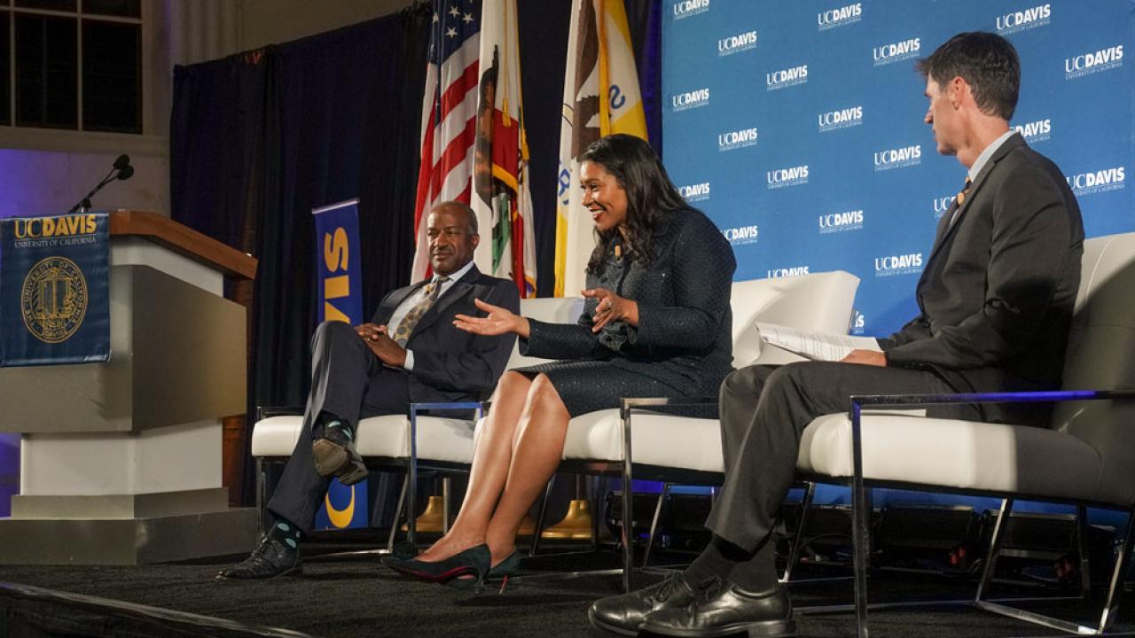 Chancellor May, Mayor Breed, Dan Brown, seated, on dais.