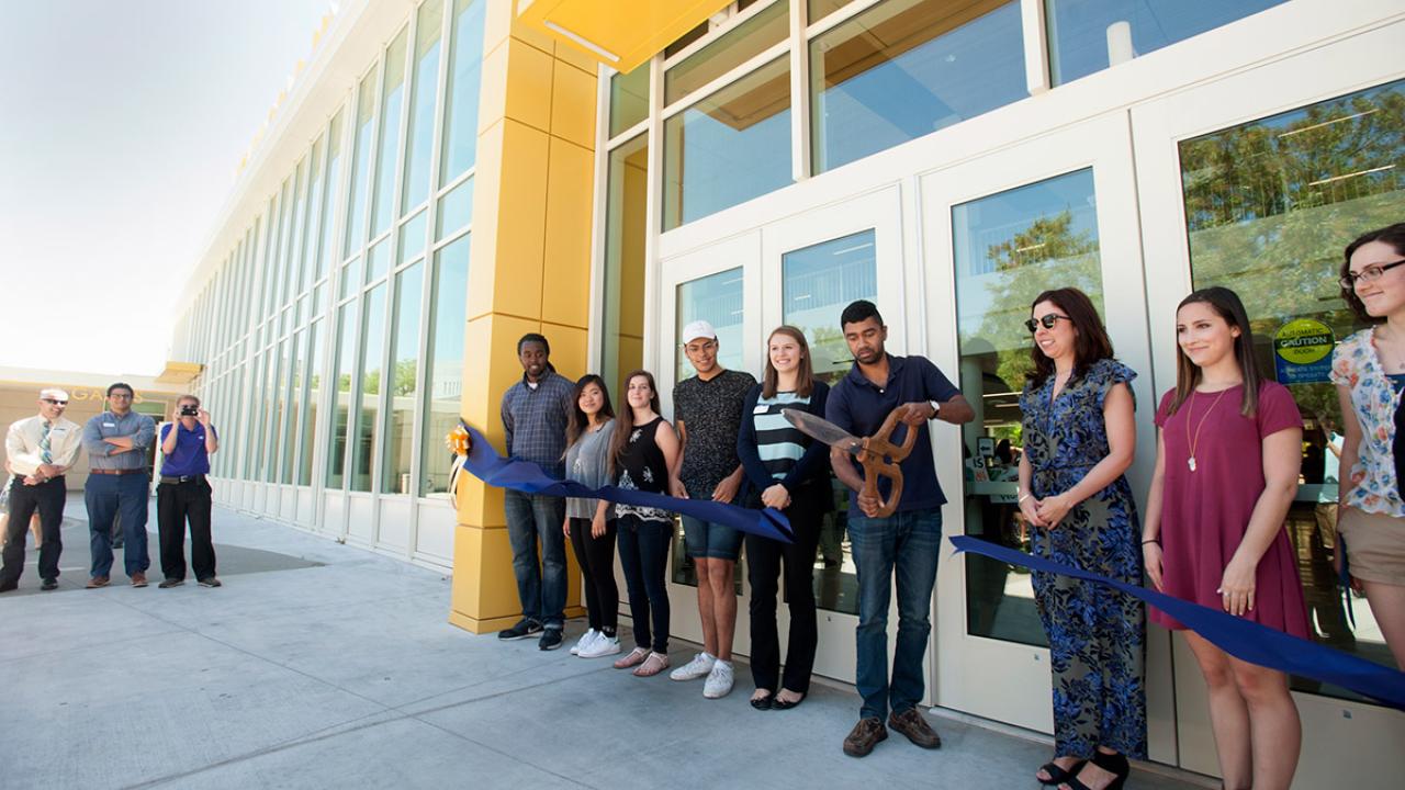 ASUCD President Josh Dalavai cuts a ceremonial ribbon at the Memorial Union.
