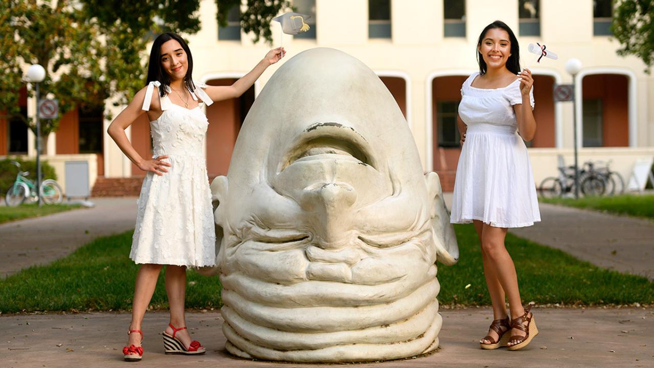 Two women pose for photo near Egghead.