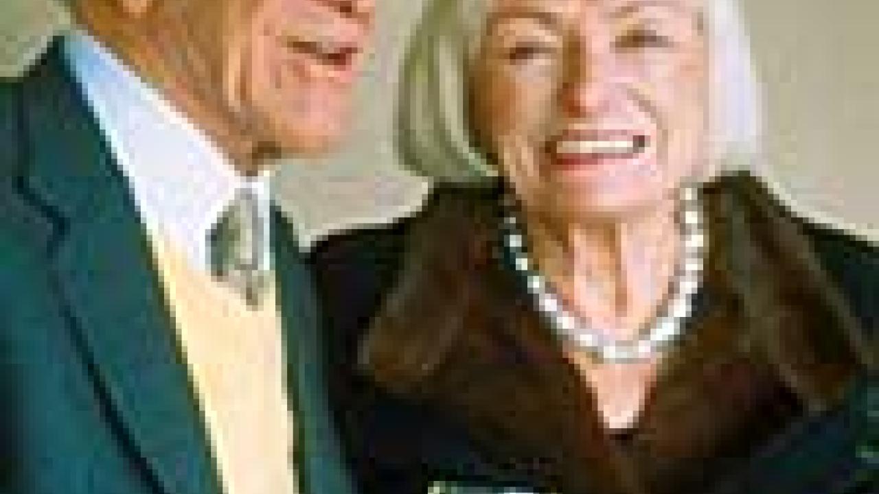 Photo: man holding wine glass next to woman with flowers