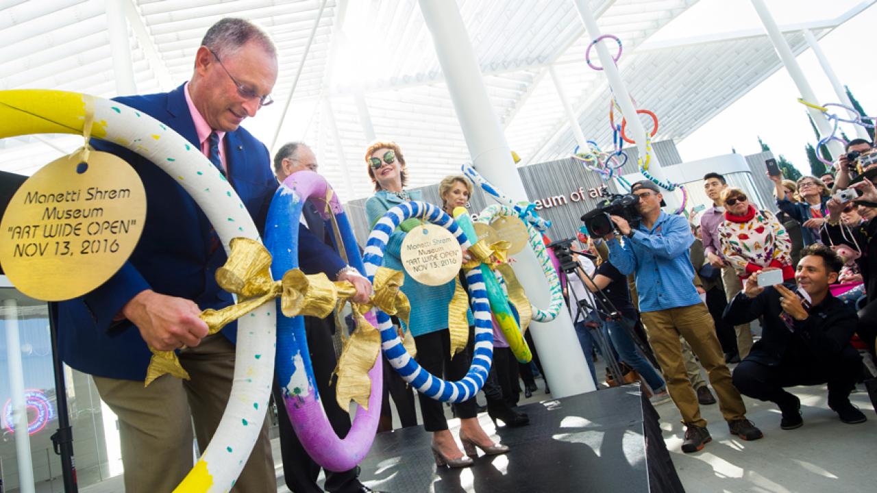 Photo: Ralph J. Hexter unties ribbon in museum chain.