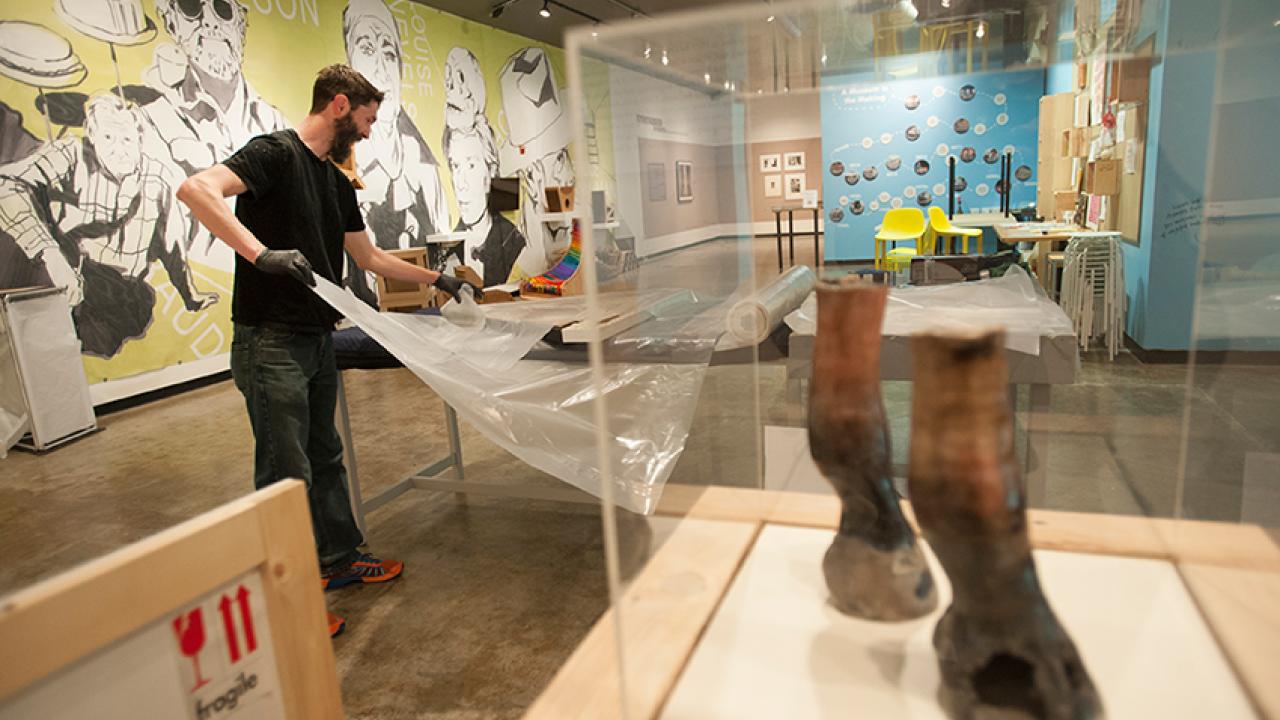 Photo: Kyle Monhollen, senior preparator, wraps a piece of art for transportation and storage.