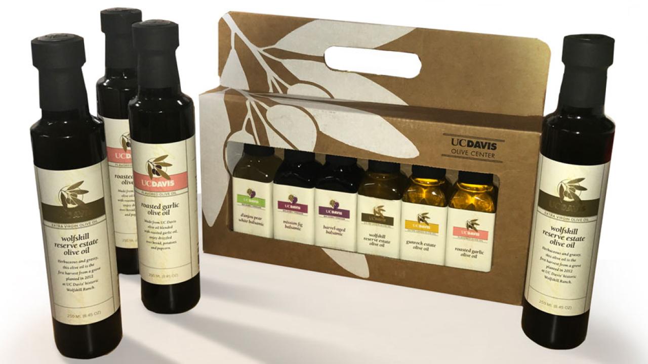 Four bottles of olive oil, displayed with deluxe sampler of six bottles in box