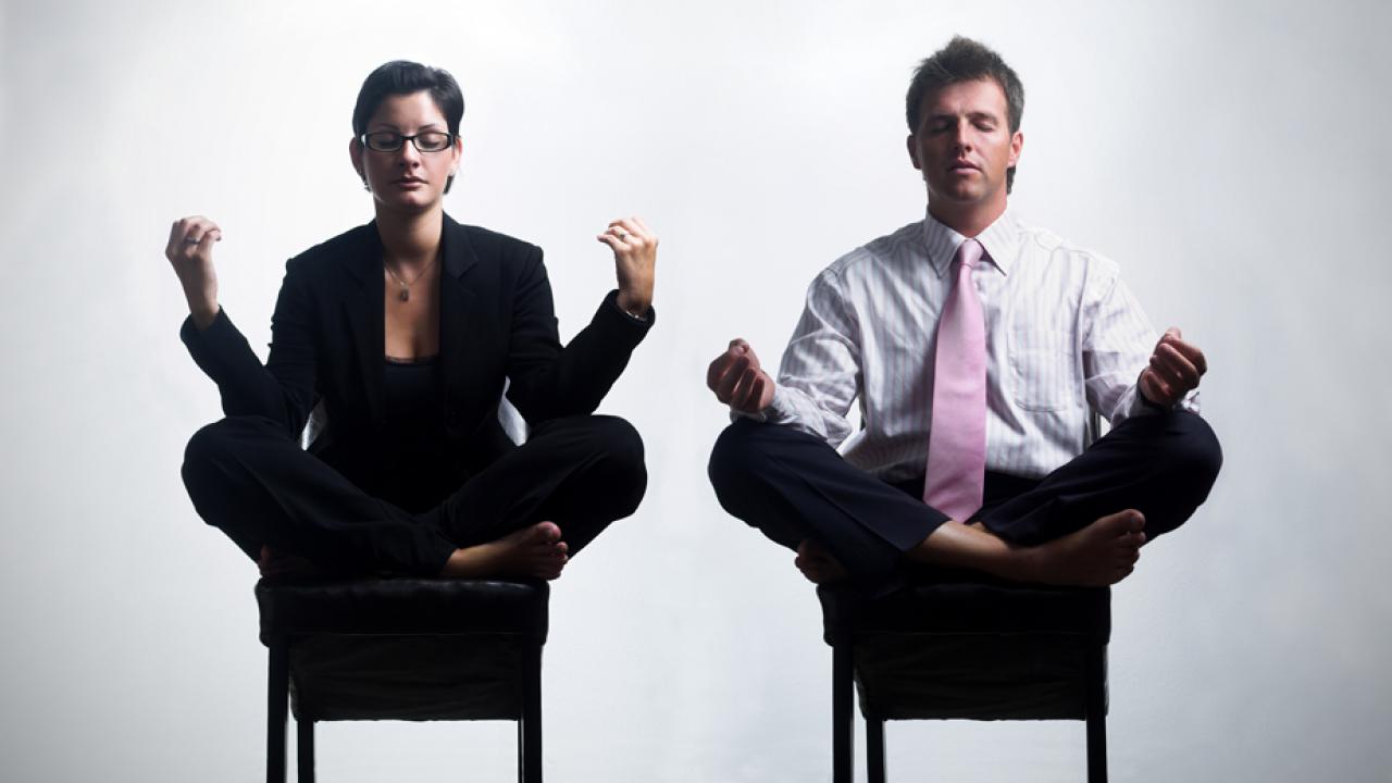 Photo: Employees meditate in chairs at work.