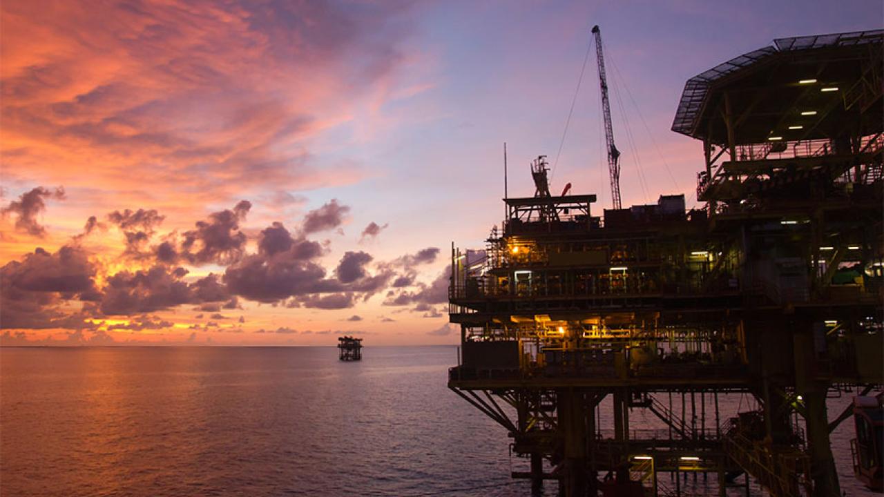 An offshore oil rig at sunset