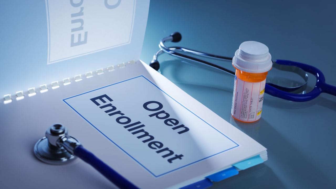 Open enrollment photo illustration, showing booklet, stethoscope and Rx bottle.
