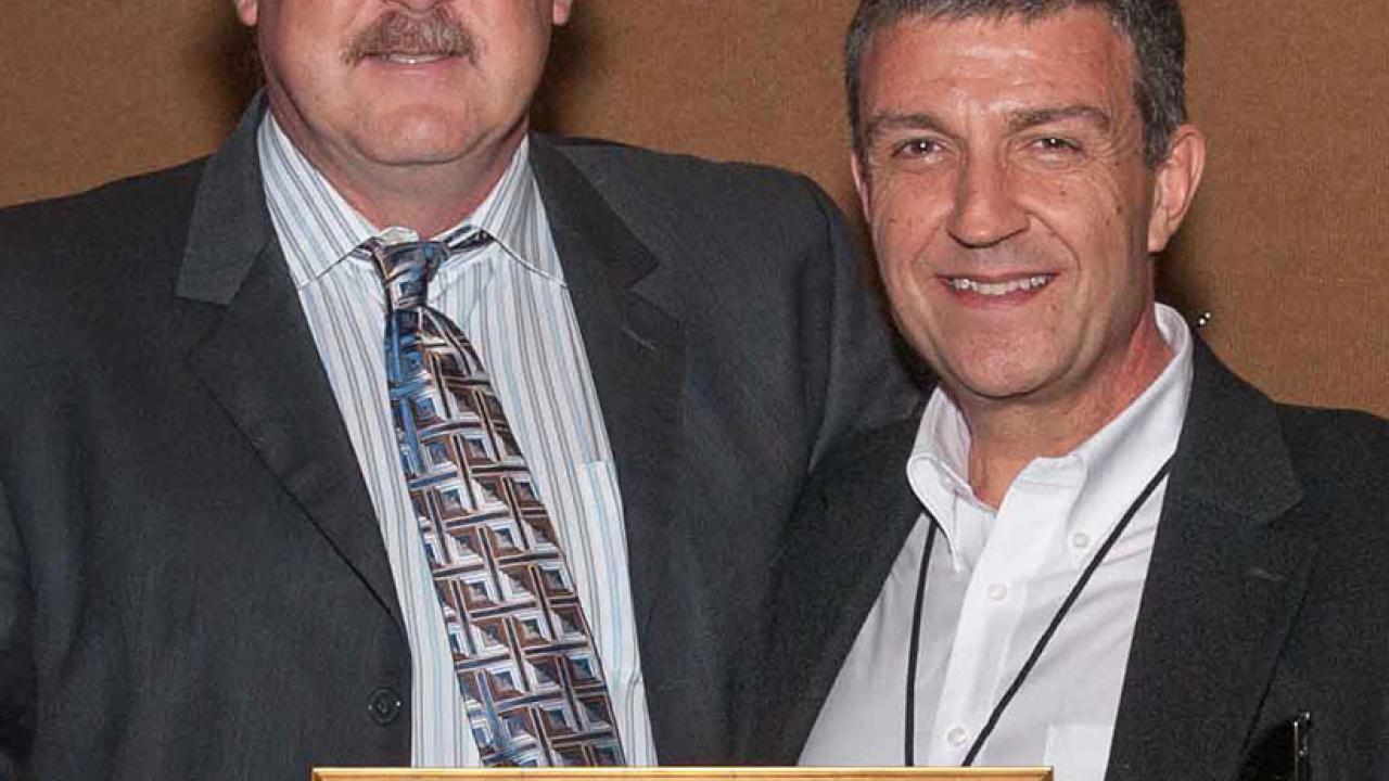 Photo: Chip Israel, outgoing president of the IES, hands framed certificate to Professor Konstantinos &ldquo;Kosta&rdquo; Papamichael.