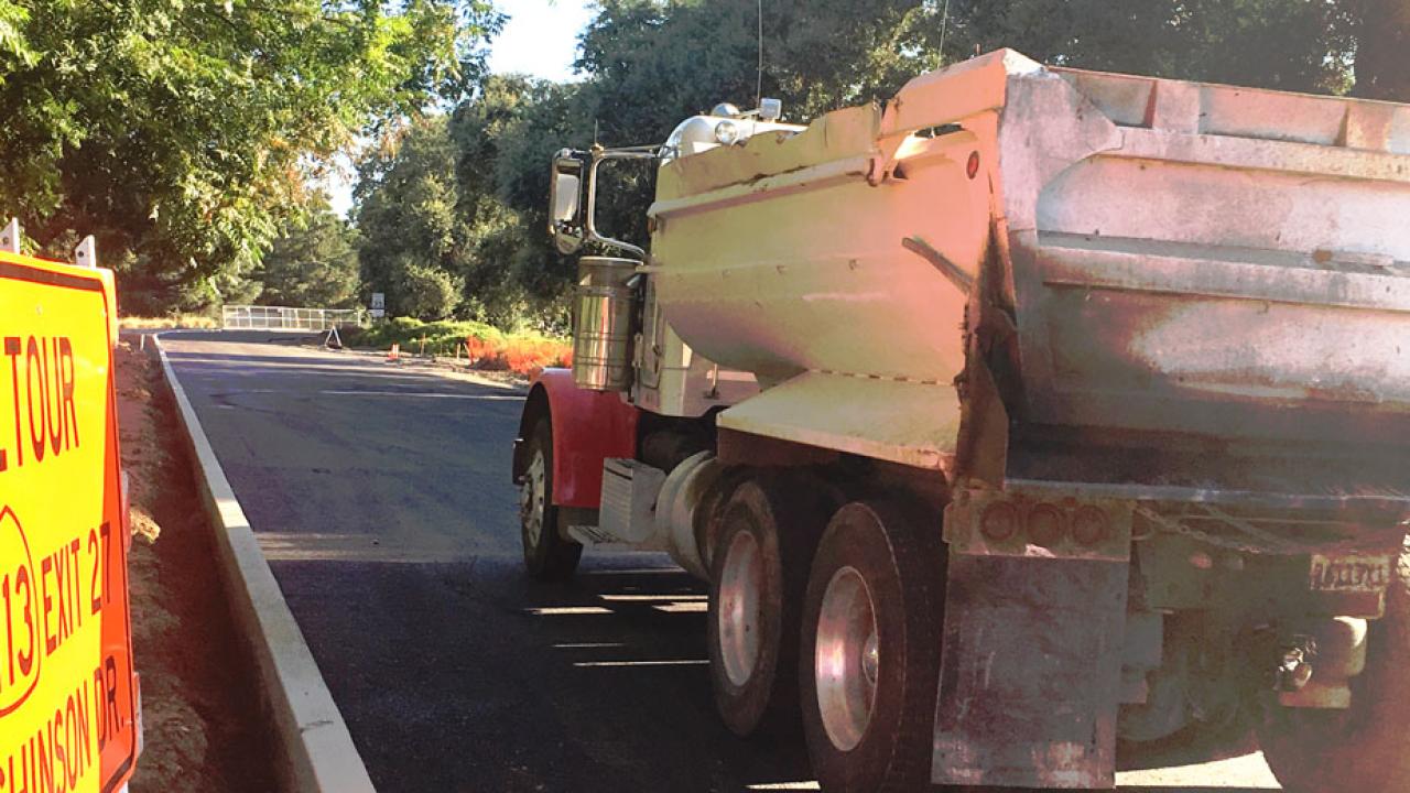 Truck carries asphalt to construction site.