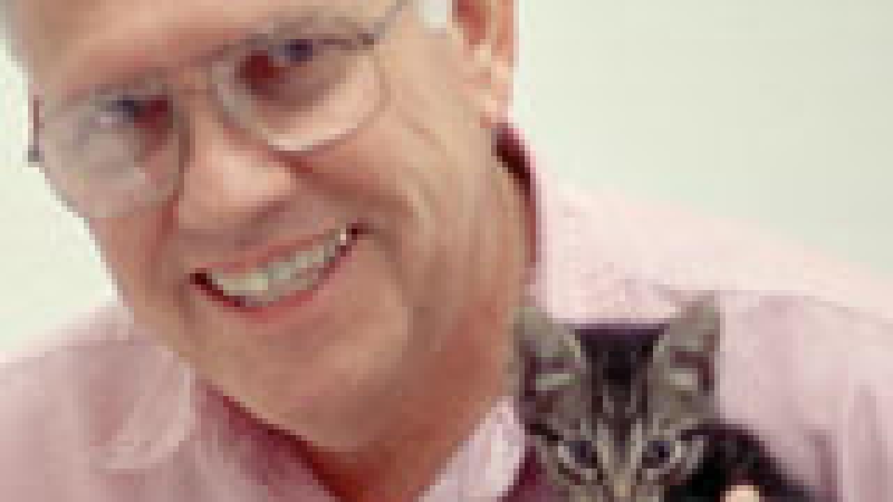 Photo of man with cat on his shoulder.