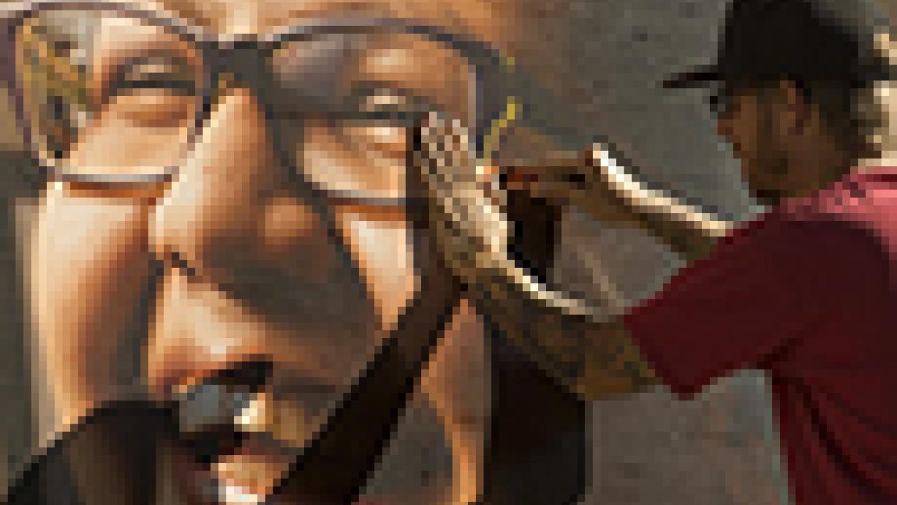 Photo: Photo: Unidentified worker casts a shadow on poster (Angel Hinzo) as he installs it.