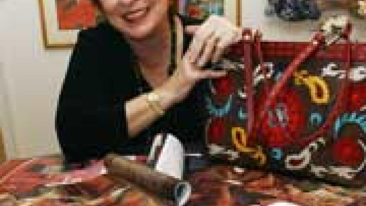 picture of Victoria Rivers surrounded by materials and catalogs.