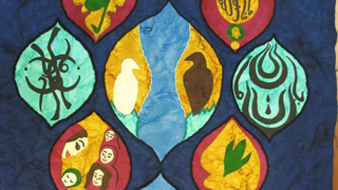 Quilt with a center pod with two birds encircled by eight smaller pods with various symbols including women, a plant and other Egyptian symbols.