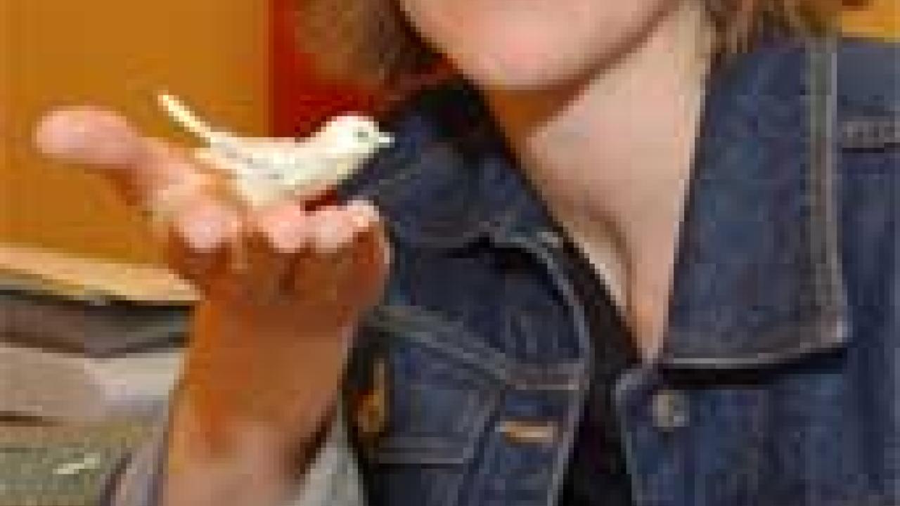 Photo: woman holding bird figure with saccharine bottle in foreground