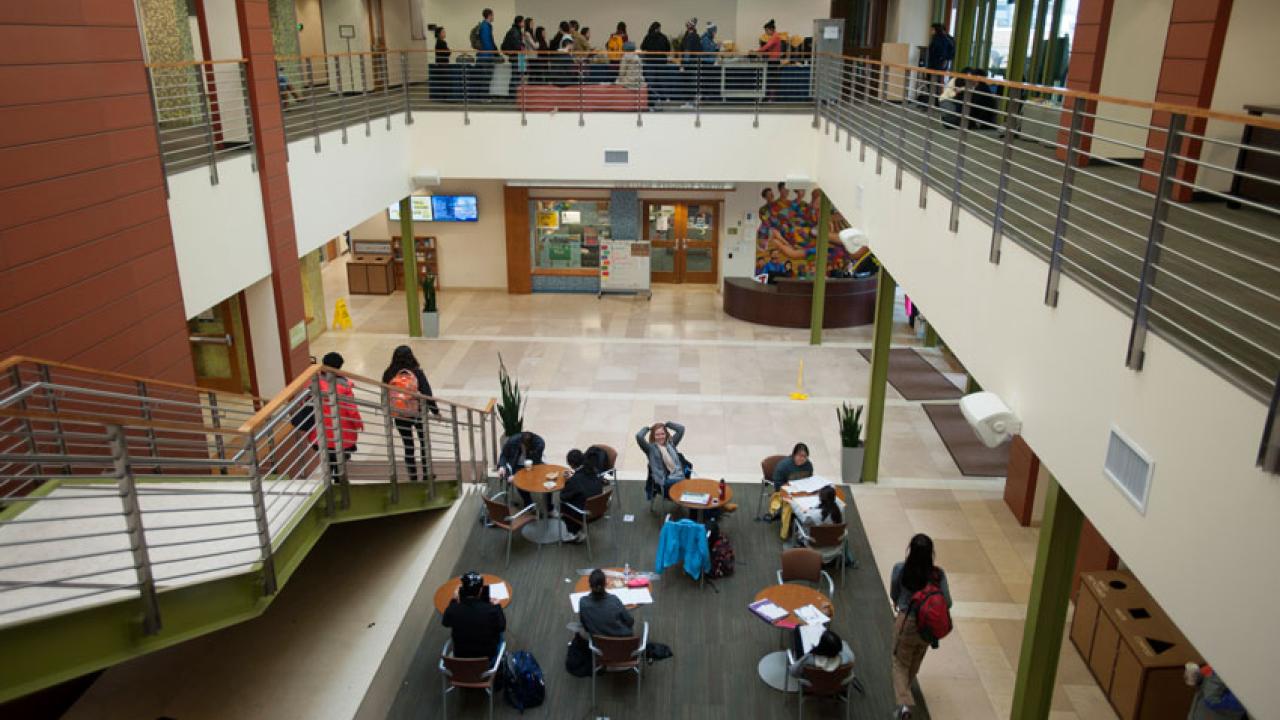 Photo: People at tables in lobby of Student Community Center.