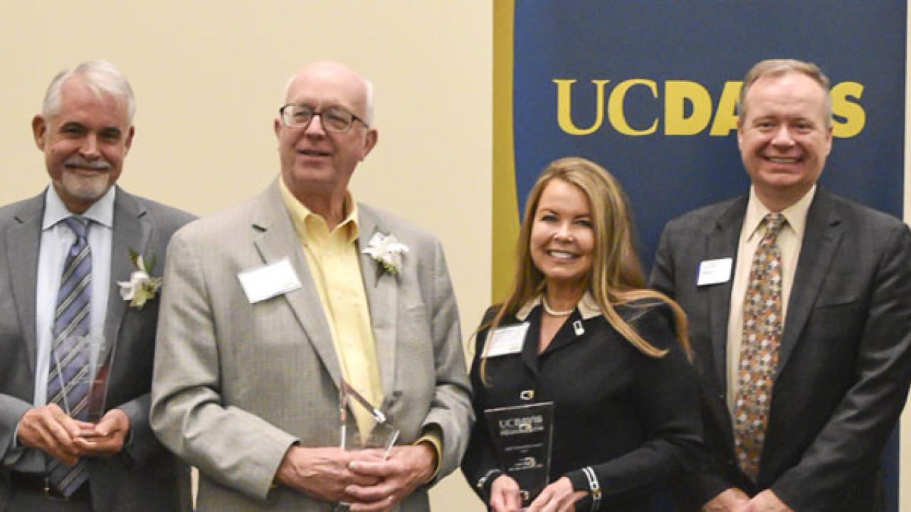 Six people, posing, in a line.