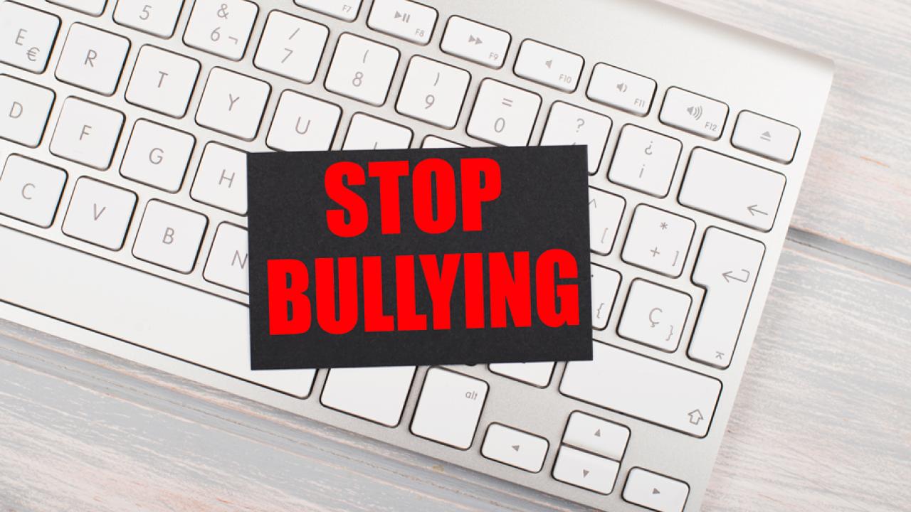 "Stop Bullying" message atop keyboard, in stock photo