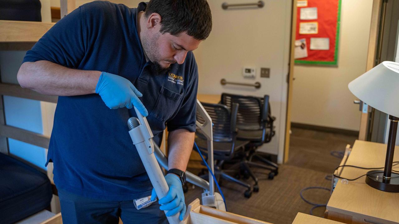 Aldo Lopez cleans a dorm room.