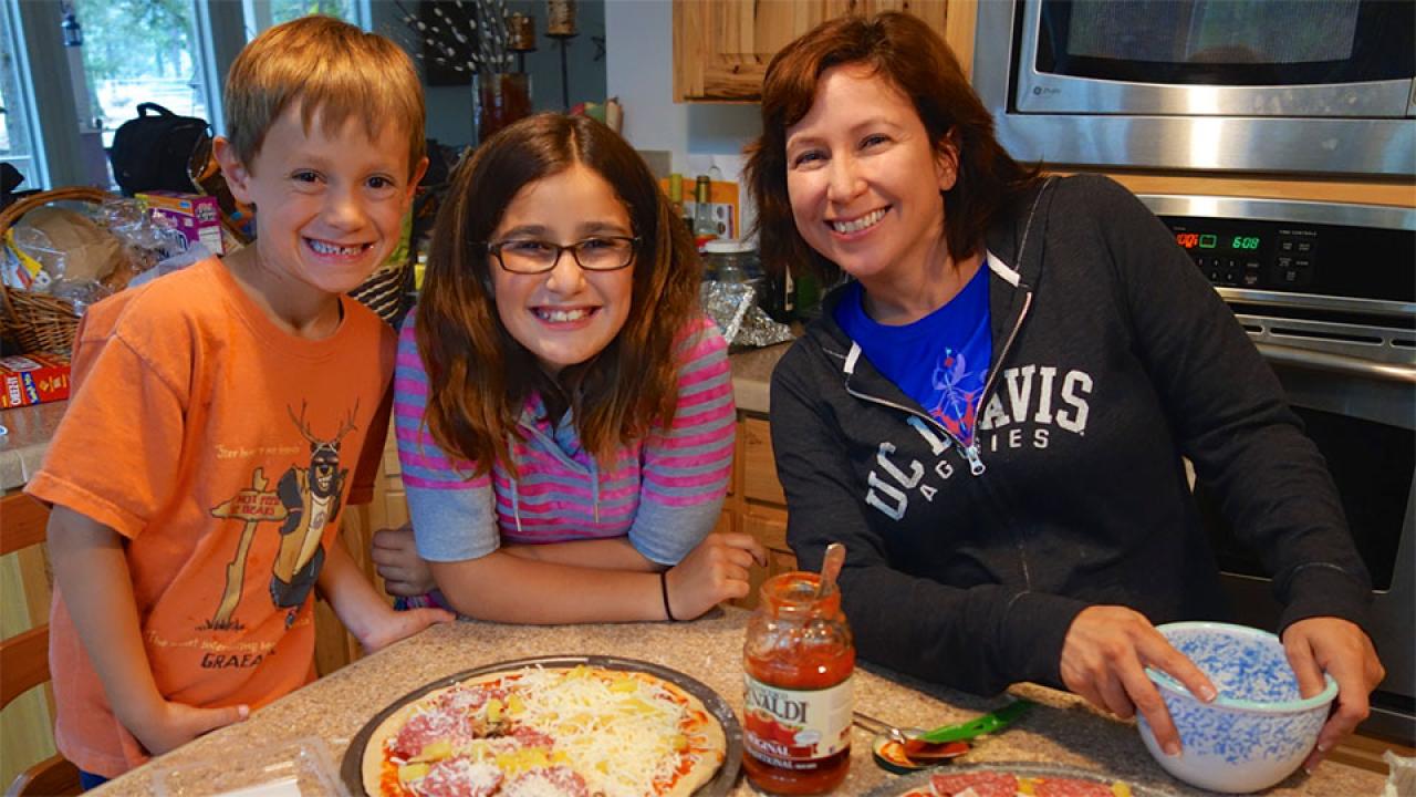 Susan Rivera and her two children making pizza at home