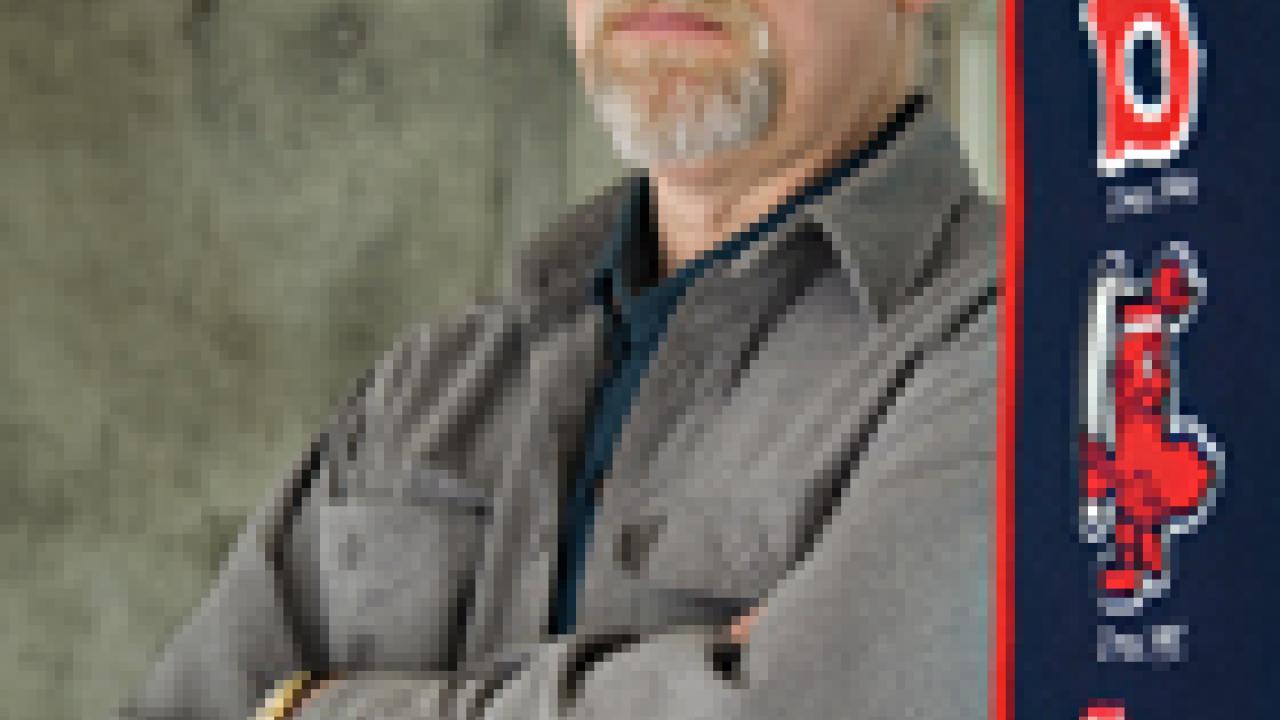 Historian Alan Taylor stands next to a Boston Red Sox banner (he is a Sox fan). Each spring Taylor helps graduate students organize a weekly game of town ball, an early 19th century baseball-style game that he learned about while doing research 