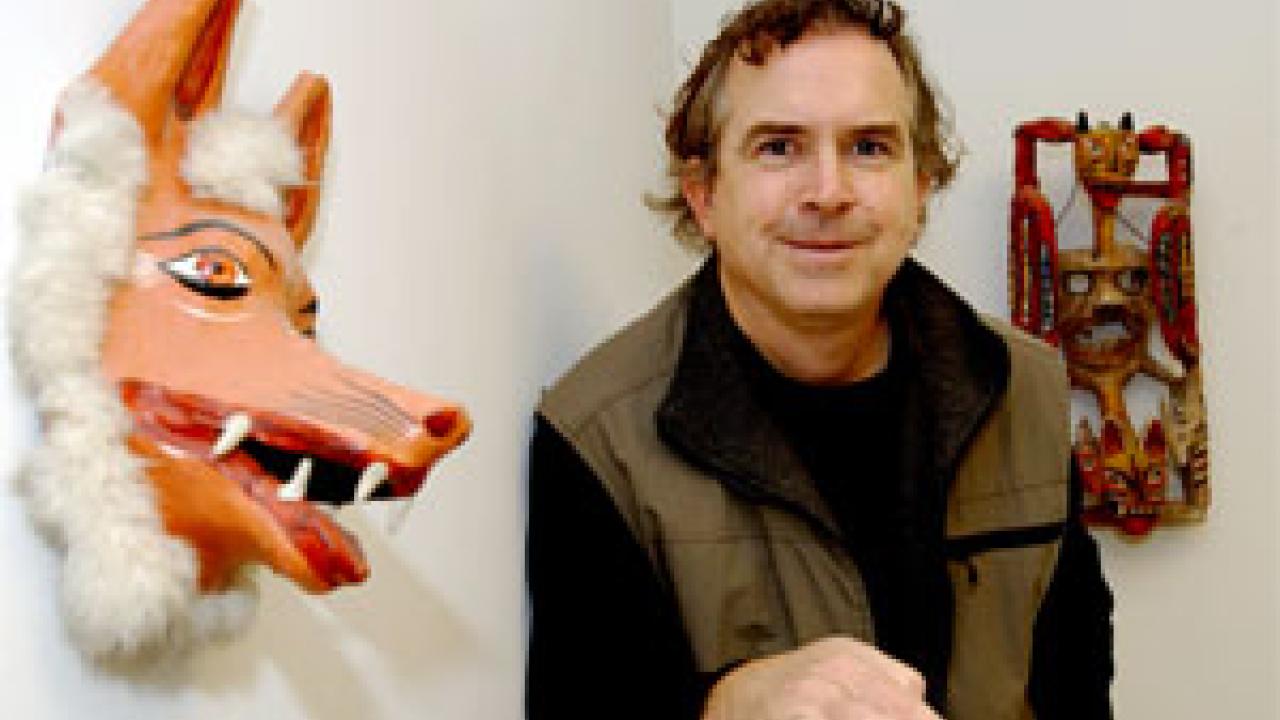 Ed Taylor stands amid souvenirs representative of his many travels throughout the world. His studies include international migration, rural economies and how economics impacts the environment.  