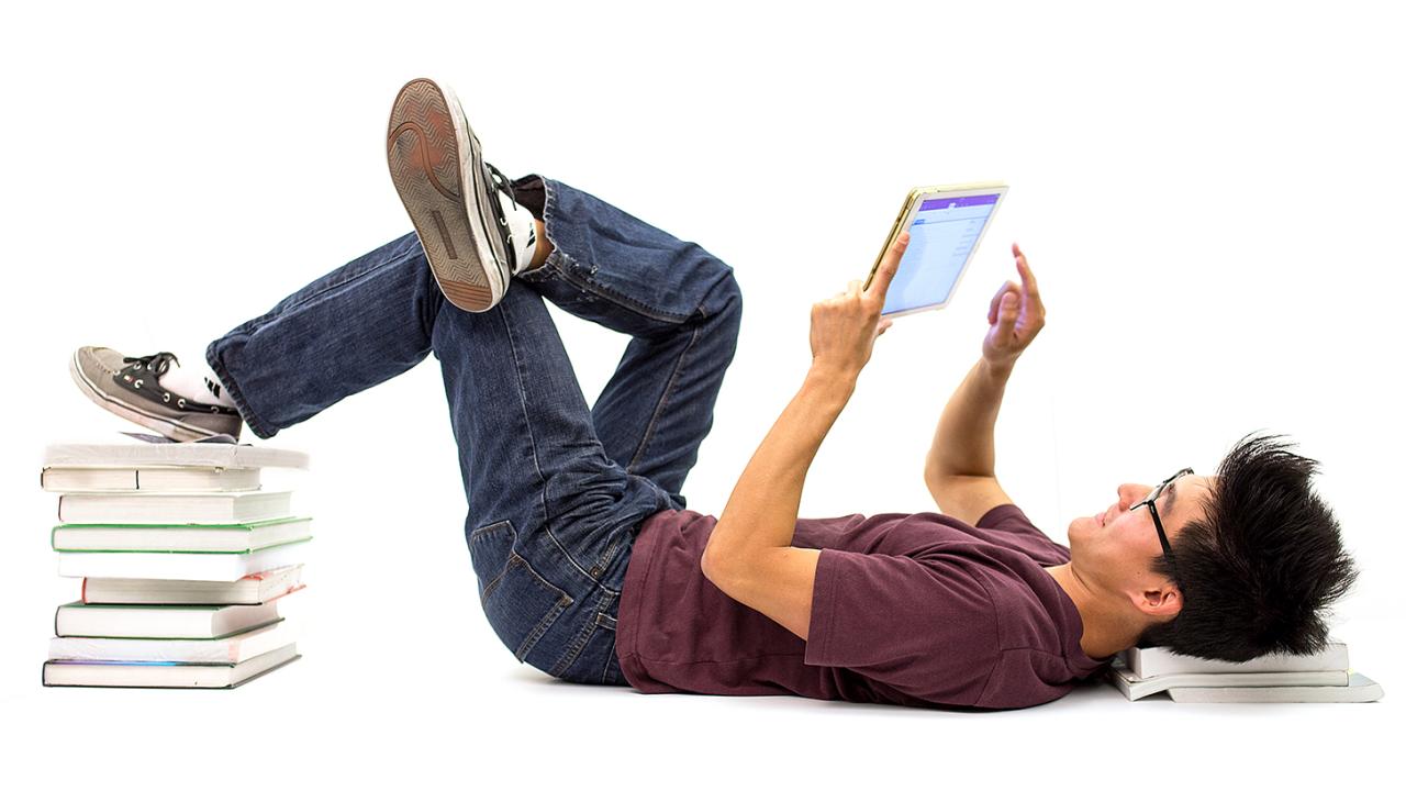 A student reads a tablet computer.