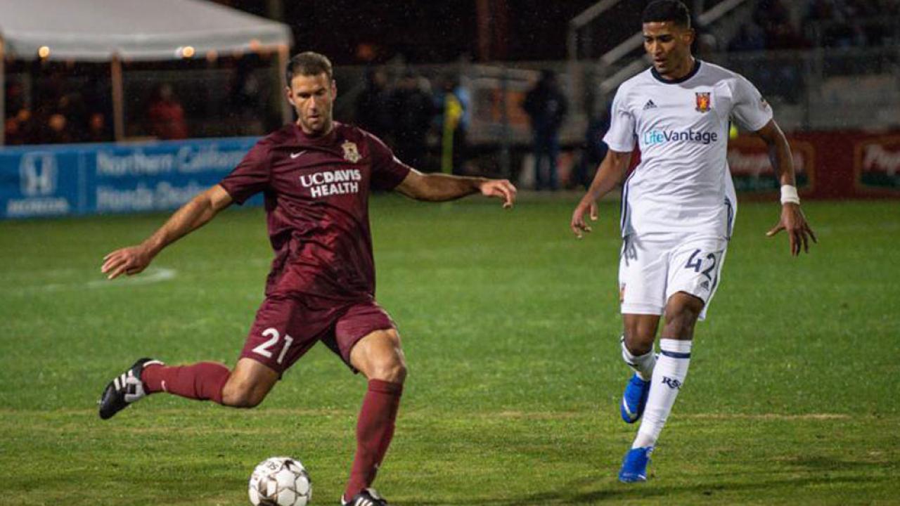 Soccer action shot, featuring player in UC Davis Health jersey.