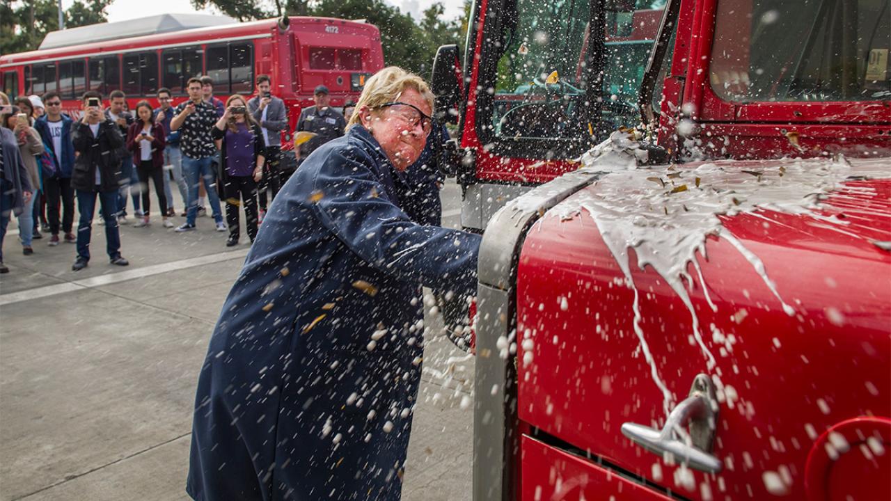 Lola Hogan breaks a bottle of beer on a Unitrans bus