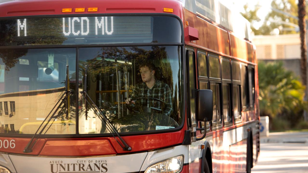 Unitrans bus, shot from the front, looking in at the driver.