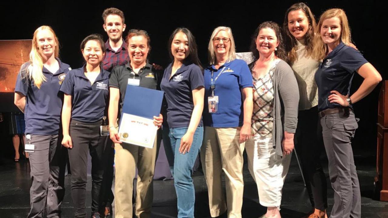 Veterinary affiliates lined up photo with certificate of commendation.
