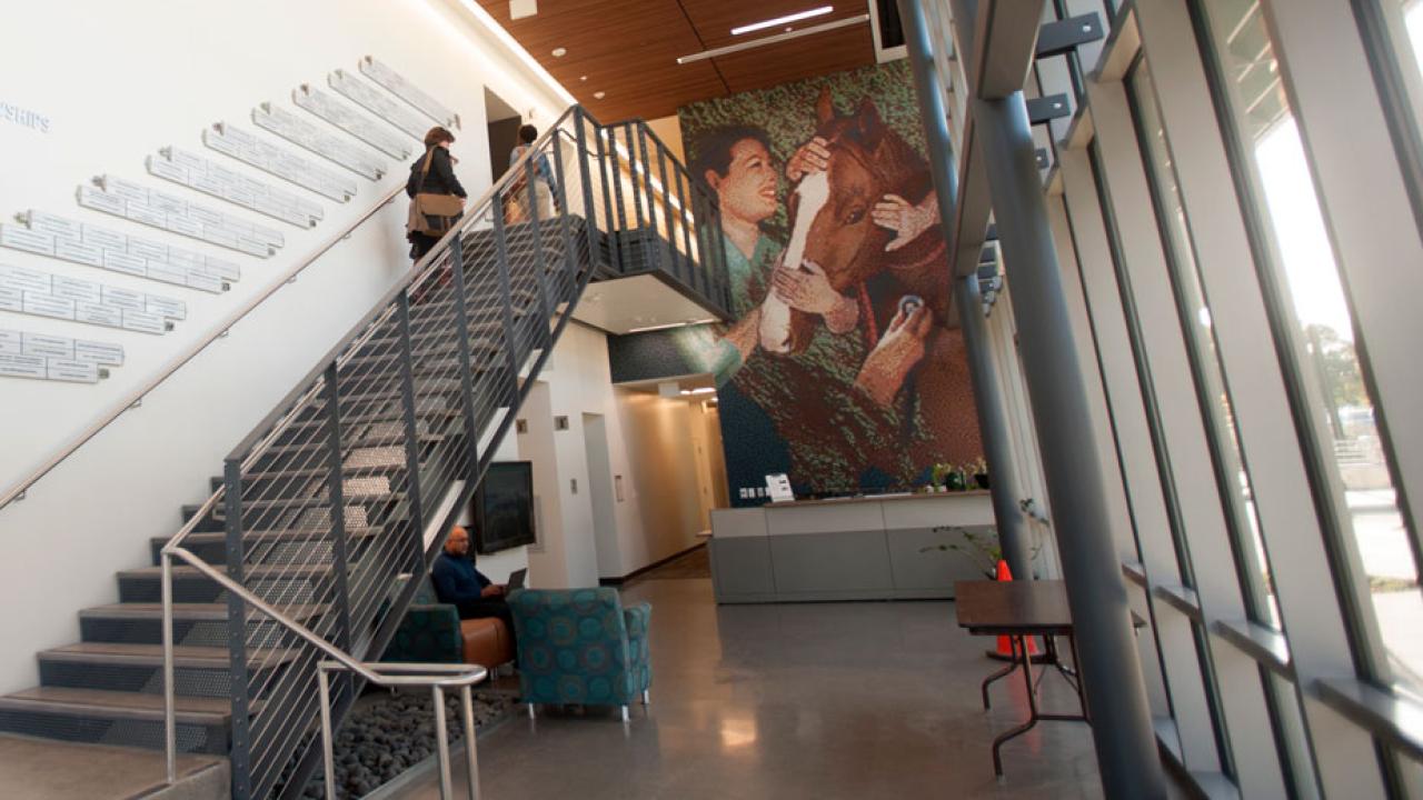 Lobby corridor with two-story-tall horse-and-hands mosaic at the end.