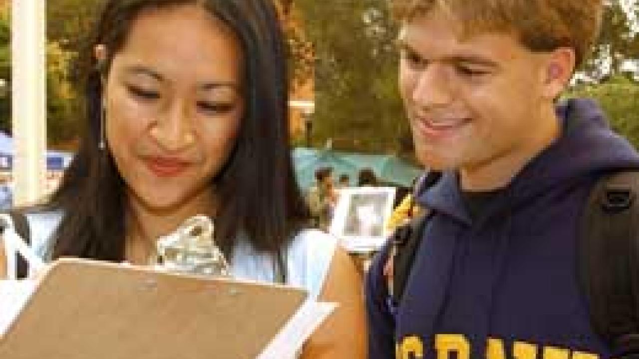 Photo: woman with clipboard with man on her right
