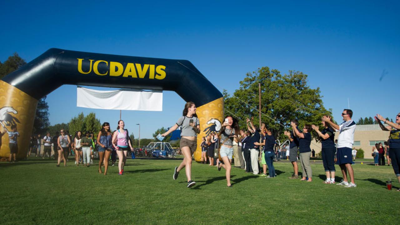 Photo: New students pass under the UC Davis arch.