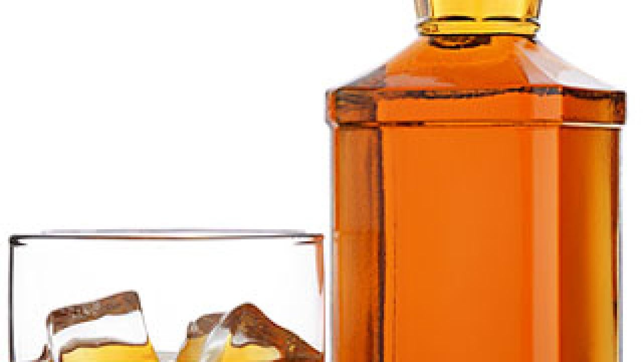 A glass of liquor and a bottle of liquor