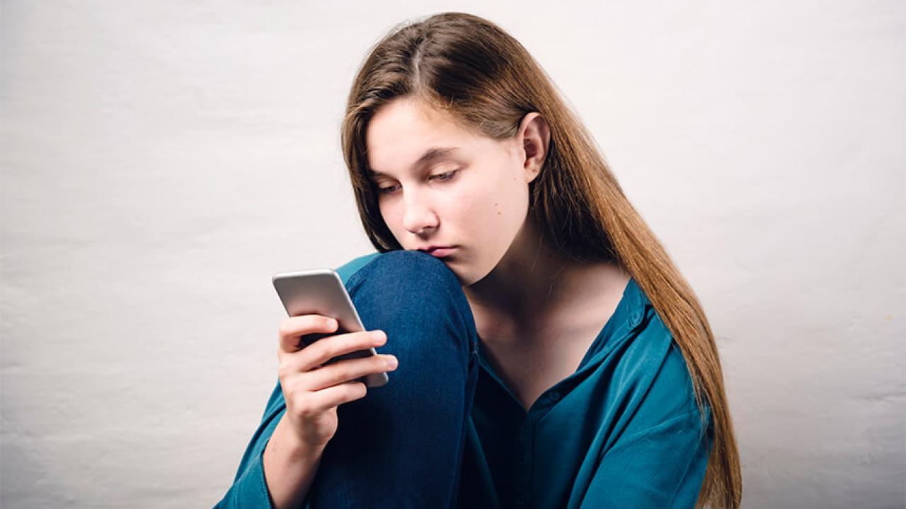 Woman looks at cellphone.