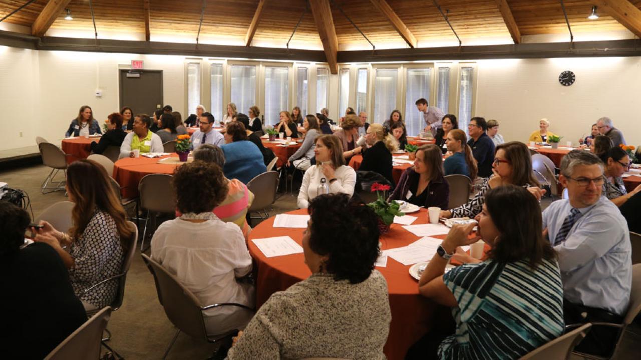 People seated around tables at luncheon.