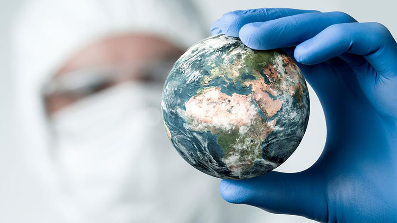 Researcher holds small world in gloved hand