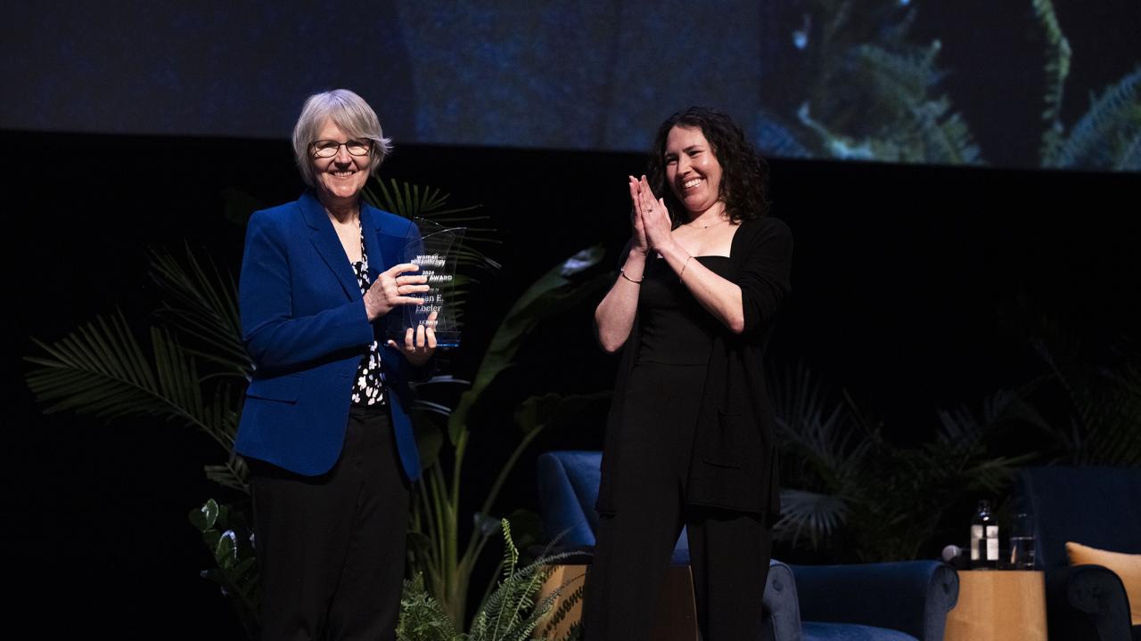 Sue Ebeler with an award next to a presenter