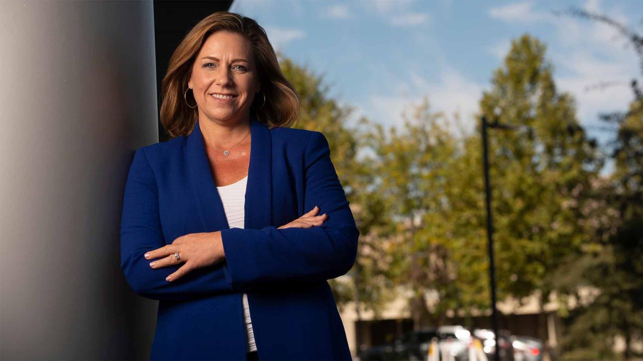 Jonna Mazet leans against a wall while wearing a blue blazer