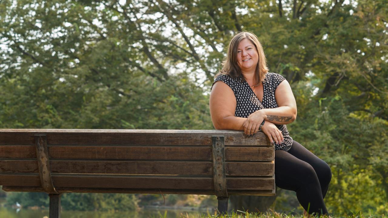 Katy Pattison smiles at a bench on the UC Davis campus. 