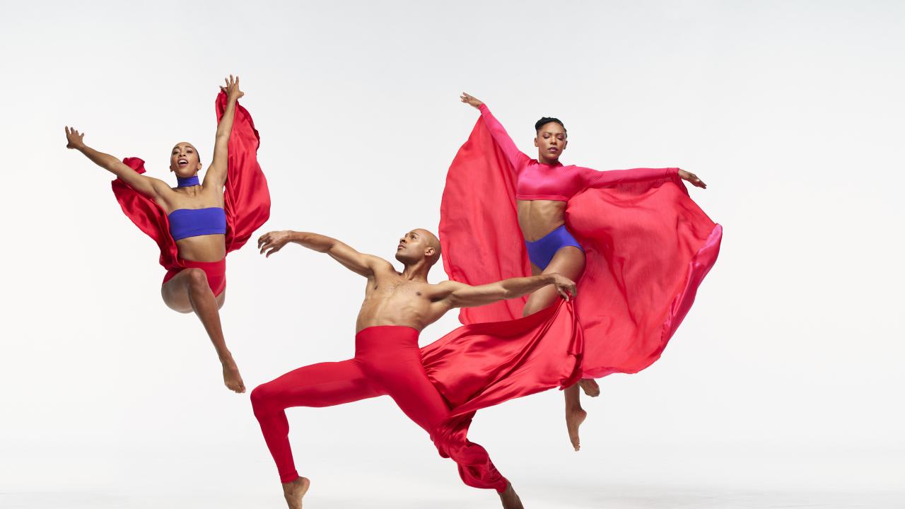 Dancers on white stage dressed in red costumes