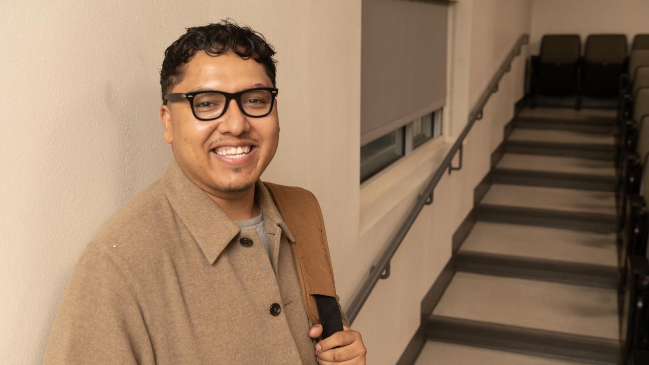 Closeup of Emmanuel Garcia Pereida against classroom wall with stairs in background